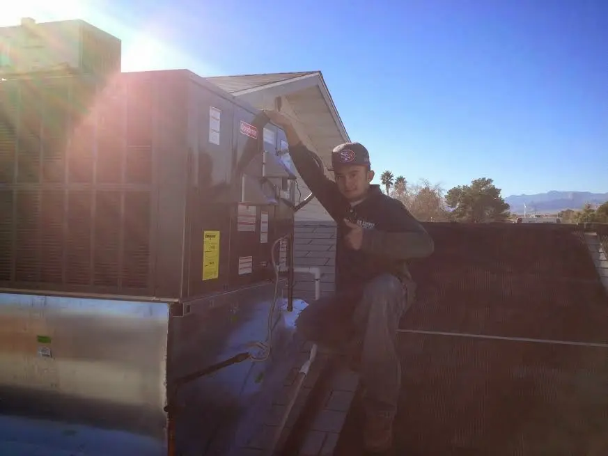 HVAC technician performing AC Tune-Up on a rooftop unit in Palmer Ranch